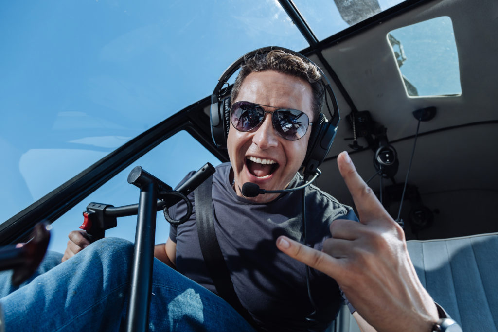 Overjoyed helicopter pilot showing sing of horns